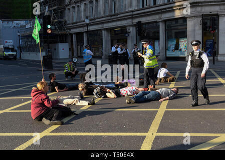 Londres, Royaume-Uni. 18 avril 2019. La route des militants se situent dans la région de Regent Street pour bloquer le chemin de la rose à voile remorqué loin de Oxford Circus pendant 'London : rébellion internationale', sur cinq jours d'une manifestation organisée par l'extinction de la rébellion. Les manifestants exigent que les gouvernements prennent des mesures contre le changement climatique. La police a émis une ordonnance exigeant que l'article 14 les protestataires à convoquer à Marble Arch que pour que la protestation peut continuer. Crédit : Stephen Chung / Alamy Live News Banque D'Images