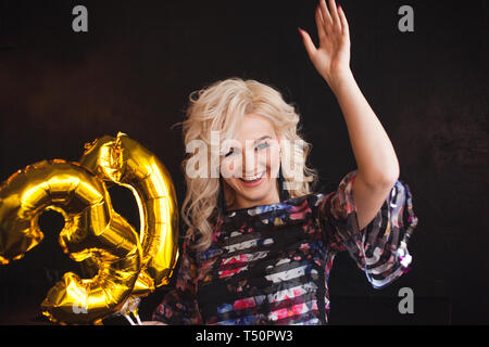 Happy young woman having fun at Birthday party. Fille d'anniversaire avec des ballons à la main. Banque D'Images