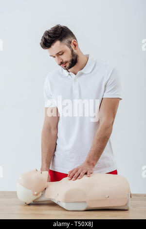 Bel homme à la RCR à faux au cours de premiers soins formation isolé sur gray Banque D'Images