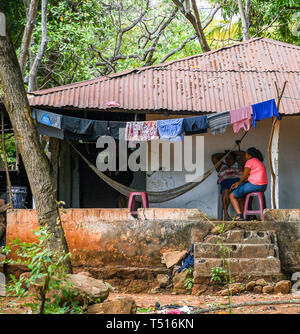 Les gens parlant à l'extérieur de Maison dans village guatémaltèque pauvre Banque D'Images