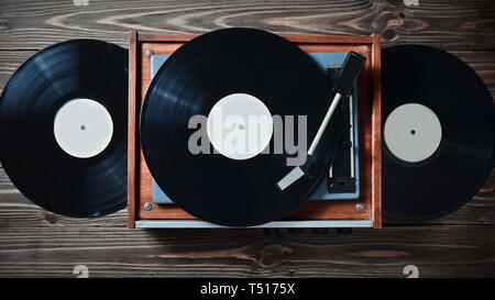 Lecteur de vinyle avec plaques sur une table en bois. Entertainment 70. Écouter de la musique. Vue d'en haut. Banque D'Images