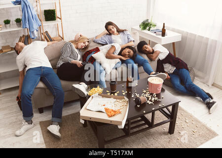 Les amis de dormir après partie dans la chambre en désordre Banque D'Images