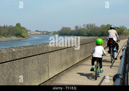 Femme et jeune garçon cycle sur le zambezi River Lodge à côté de la Tamise dans Barnes, Londres, Angleterre Banque D'Images