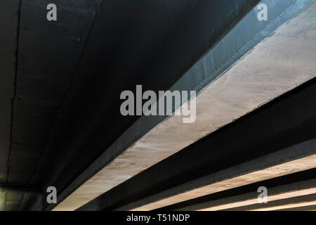 Vue de dessous le grand pont de l'autoroute en béton de l'autre côté de la rivière. Banque D'Images