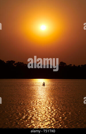 Coucher de soleil sur Srah Srang avec un pêcheur dans le lac Banque D'Images