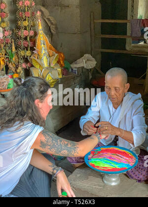 Siem Reap, Cambodge - Mars 26, 2019 : les touristes qui reçoit la bénédiction de la nonne bouddhiste dans le temple à Angkor au Cambodge complexe. Banque D'Images