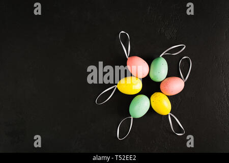 Colorés de pâques oeufs pastel en cercle avec des rubans sur fond de béton texturé en arrière avec l'exemplaire de l'espace. Six faux oeufs décoration. L'espace pour le texte. F Banque D'Images