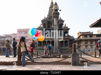 Katmandou, Népal - 15 janvier 2016 : Petite marchande de ballons dans la cour en face de Krishna Mandir à Patan Durbar Square. Banque D'Images