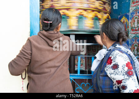 Katmandou, Népal - Novembre 11, 2017 : les femmes âgées en priant pour un moulin à prière dans les locaux de Bhagwan Pau. Banque D'Images