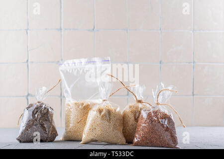 Super aliment set - quinoa, Chia, de graines de lin contre le mur avec les carreaux de céramique Banque D'Images