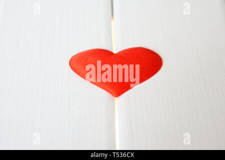 Cœur rouge sur une surface en bois blanc et lumineux. Les problèmes de santé et la cardiologie. Préparation de félicitations à l'occasion de la Saint-Valentin. Banque D'Images