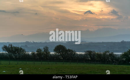 Lever du soleil à Brynsiencyn, Anglesey, au nord du Pays de Galles, UK donnant sur le détroit de Menai et montagnes de Snowdonia. Prise le 9 avril 2019. Banque D'Images