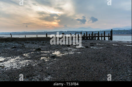 Pier abandonnés sur les rives de la Détroit de Menai au lever du soleil. Voir d'Anglesey, dans le Nord du Pays de Galles, Royaume-Uni. Prise le 9 avril 2019. Banque D'Images