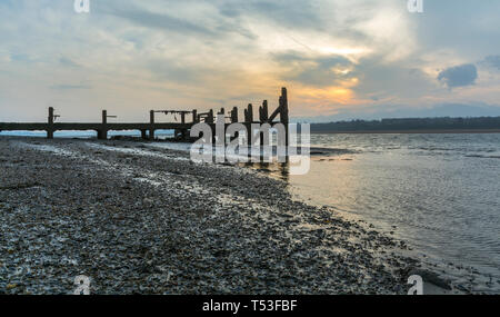 Pier abandonnés sur les rives de la Détroit de Menai au lever du soleil. Voir d'Anglesey, dans le Nord du Pays de Galles, Royaume-Uni. Prise le 9 avril 2019. Banque D'Images