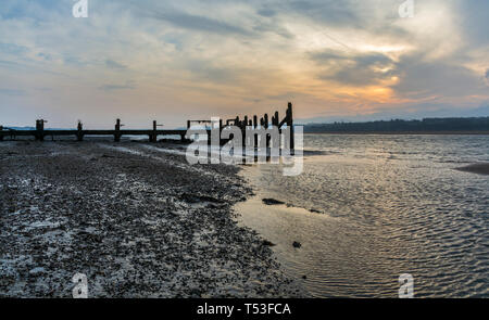 Pier abandonnés sur les rives de la Détroit de Menai au lever du soleil. Voir d'Anglesey, dans le Nord du Pays de Galles, Royaume-Uni. Prise le 9 avril 2019. Banque D'Images