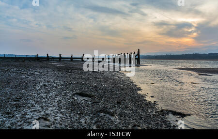 Pier abandonnés sur les rives de la Détroit de Menai au lever du soleil. Voir d'Anglesey, dans le Nord du Pays de Galles, Royaume-Uni. Prise le 9 avril 2019. Banque D'Images