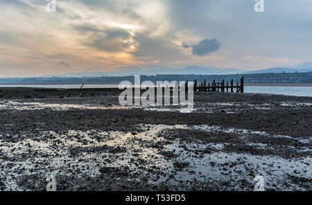 Pier abandonnés sur les rives de la Détroit de Menai au lever du soleil. Voir d'Anglesey, dans le Nord du Pays de Galles, Royaume-Uni. Prise le 9 avril 2019. Banque D'Images