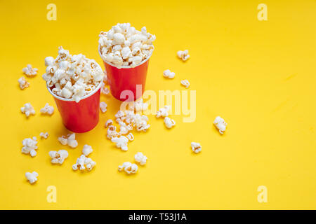 Pop corn salé frais dans deux conteneurs carton rouge, jaune fond couleur, copy space Banque D'Images