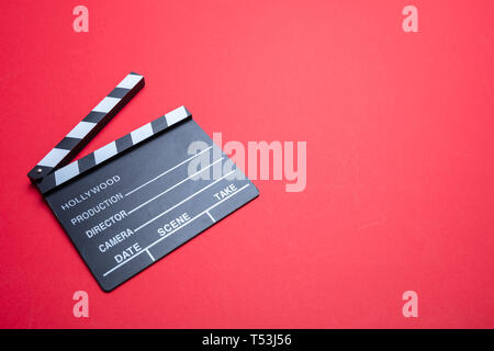 Cinama du concept du film. Movie clapper board sur fond de couleur rouge, copy space Banque D'Images