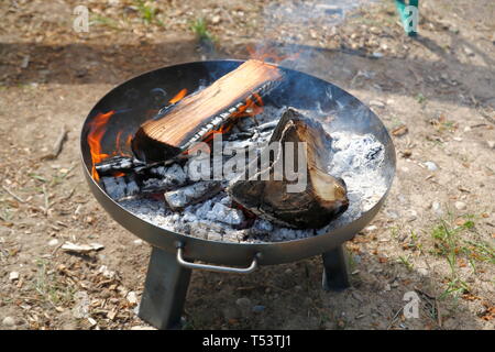 Feuer in einer Feuerschale, Holzgrille mit grosser Asche Banque D'Images