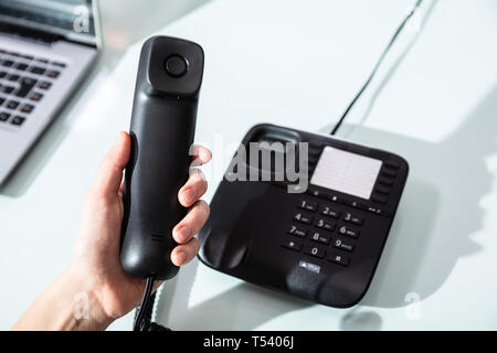 Close-up of a woman's Hand composant le numéro de téléphone à appeler dans Office Banque D'Images