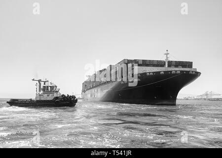 Photo en noir et blanc du navire porte-conteneurs, CMA CGM CENTAURUS, tourné de 180 degrés par un remorqueur JOHN QUIGG, avant d'arriver à Long Beach, USA. Banque D'Images