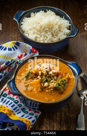 Poulet ragoût d'arachide africaine avec les patates douces et le gombo avec côté de riz basmati Banque D'Images