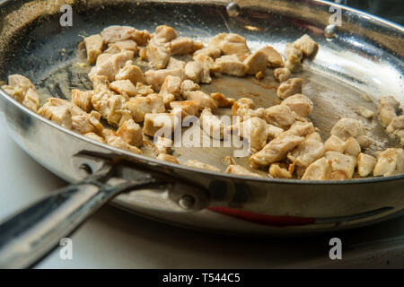 La cuisson du poulet en cubes de taille de morsure en acier inoxydable grand wok casserole pour fajitas Banque D'Images