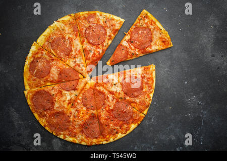 Italian Pizza Pepperoni sur fond noir en sombre Banque D'Images