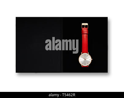 Women's Classic gold montre avec cadran blanc, bracelet en cuir rouge, d'isoler sur un fond blanc. Vue d'en haut dans la boîte. Banque D'Images