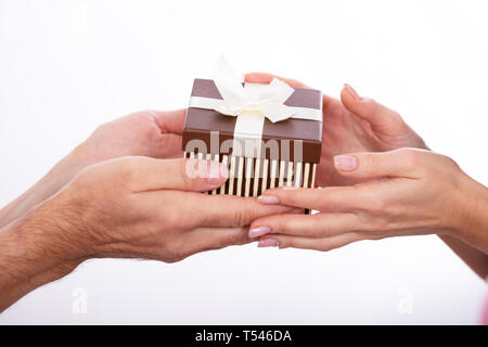 Close-up of Woman's Hand Holding Gift Box Against White Background Banque D'Images