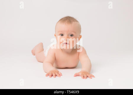 Cute little baby boy aux couches de ramper sur fond blanc lumineux,photo de ramper bébé curieux sur backgroubd blanc Banque D'Images