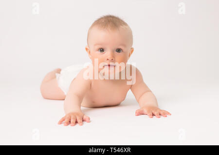 Cute little baby boy aux couches de ramper sur fond blanc lumineux,photo de ramper bébé curieux sur backgroubd blanc Banque D'Images