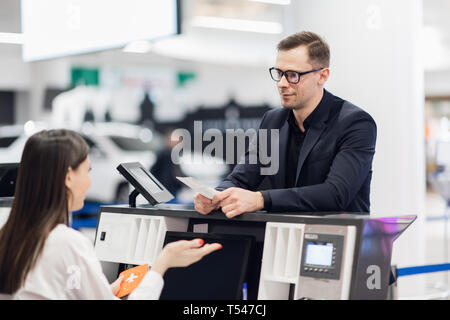 Handsome businessman handing over air billet au comptoir de compagnie aérienne Banque D'Images