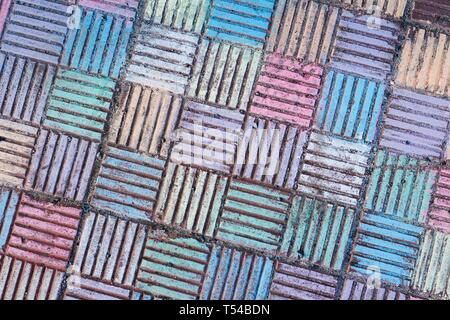 Les petites formes en béton en forme de carrés sont peints avec de la craie de couleurs et de nuances. Cela a été fait par des enfants jouant dans la rue. Banque D'Images