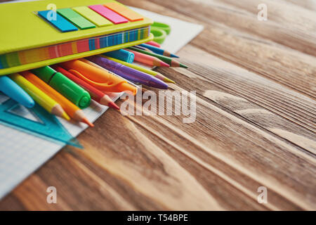 Concept de l'éducation. Stylos, crayons, marqueurs, règle et pinceau sur portable. sur un fond de bois de mise à plat. Banque D'Images