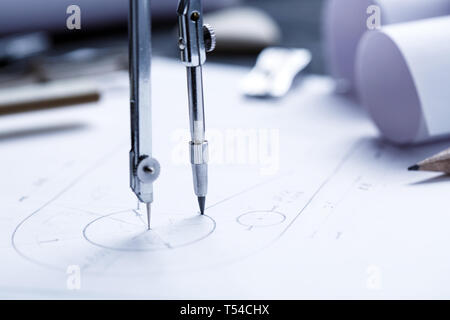 Apprendre à dessiner des cercles avec un compas. Compas et règle d'architecte mis sur le bureau, rempli de plans de bâtiment dessin industriel un détail. Banque D'Images