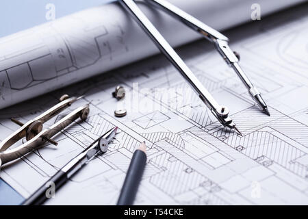 Compas sur les détails de l'élaboration industrielle. fond architectural avec rouleaux de dessins techniques et les bleus au point sélective. Banque D'Images