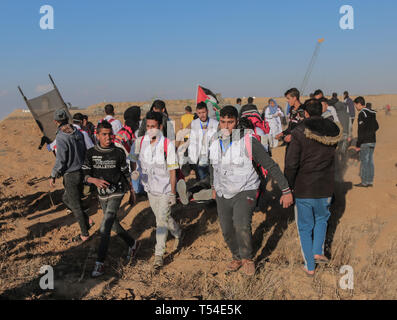 Gaza, Khan Younis, Palestine. Apr 19, 2019. Les médecins palestiniens ont vu porter un manifestant blessé lors de la manifestation.Palestiniens entrent en conflit avec les forces israéliennes au cours d'une manifestation appelant à la levée du blocus israélien de Gaza et exigeant pour le droit de retourner dans leur patrie, à l'Israel-Gaza clôture frontalière dans le sud de la bande de Gaza. Credit : Yousef Masoud SOPA/Images/ZUMA/Alamy Fil Live News Banque D'Images