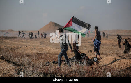 Gaza, Khan Younis, Palestine. Apr 19, 2019. Un manifestant palestinien vu tenant un drapeau pendant la manifestation.Palestiniens entrent en conflit avec les forces israéliennes au cours d'une manifestation appelant à la levée du blocus israélien de Gaza et exigeant pour le droit de retourner dans leur patrie, à l'Israel-Gaza clôture frontalière dans le sud de la bande de Gaza. Credit : Yousef Masoud SOPA/Images/ZUMA/Alamy Fil Live News Banque D'Images