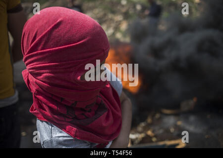 Kafr Qaddum, Qalqilya, Palestine. Apr 19, 2019. Un manifestant est vu avec son visage couvert pendant les affrontements.palestiniens se sont affrontés avec l'armée israélienne au cours de la démonstration dans le village de Kafr Qaddum. Palestiniens mars chaque vendredi et samedi dans le village de Kafr Qaddum depuis 2011 en raison de la fermeture de l'une de leurs routes et la confiscation des terres par les autorités israéliennes. Ces décisions ont été prises pour étendre la colonie de Kedumim. Grâce à cette route, les Palestiniens ont été en mesure de parvenir à la principale ville de Naplouse, en 15 minutes, maintenant il faut plus de 45 minutes. (Crédit Image : © BR Banque D'Images