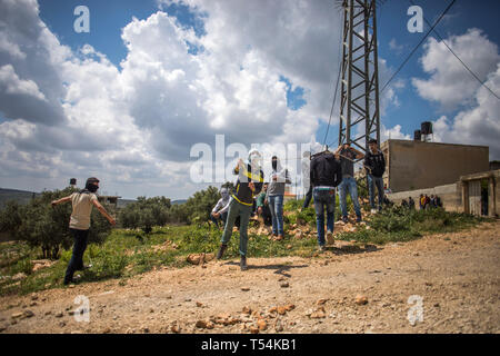 La Palestine. Apr 19, 2019. Vu Palestiniens jetant des pierres sur les forces israéliennes au cours des affrontements. Les Palestiniens se sont affrontés au cours de la démonstration de l'armée israélienne dans le village de Kafr Qaddum. Palestiniens mars chaque vendredi et samedi dans le village de Kafr Qaddum depuis 2011 en raison de la fermeture de l'une de leurs routes et la confiscation des terres par les autorités israéliennes. Ces décisions ont été prises pour étendre la colonie de Kedumim. Grâce à cette route, les Palestiniens ont été en mesure de parvenir à la principale ville de Naplouse, en 15 minutes, maintenant il faut plus de 45 minutes. Credit : SOPA Images Limited/Ala Banque D'Images