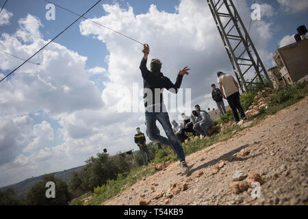 La Palestine. Apr 19, 2019. Vu Palestiniens jetant des pierres sur les forces israéliennes au cours des affrontements. Les Palestiniens se sont affrontés au cours de la démonstration de l'armée israélienne dans le village de Kafr Qaddum. Palestiniens mars chaque vendredi et samedi dans le village de Kafr Qaddum depuis 2011 en raison de la fermeture de l'une de leurs routes et la confiscation des terres par les autorités israéliennes. Ces décisions ont été prises pour étendre la colonie de Kedumim. Grâce à cette route, les Palestiniens ont été en mesure de parvenir à la principale ville de Naplouse, en 15 minutes, maintenant il faut plus de 45 minutes. Credit : SOPA Images Limited/Ala Banque D'Images