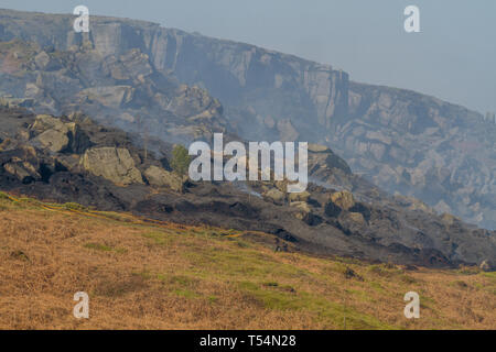 UK Moorland Fire : Ilkley, West Yorkshire, Royaume-Uni. 21 avril 2019. Poursuivre les efforts des pompiers pour éteindre les incendies dans cet endroit populaire et la faune haven sur Ilkley Moor. Ici un article en vertu de Rocky Valley continue à fumer. Rebecca Cole/Alamy Live News Banque D'Images