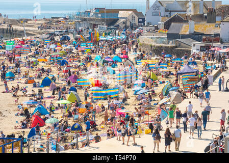 Lyme Regis, dans le Dorset, UK. 21 avril 2019. Météo France : visiteurs affluent à la plage bondée à Lyme Regis pour se prélasser au soleil brûlant le dimanche de Pâques. Se prélasser au soleil, une chaleur étouffante sur les plages de la ville sur une plaque à pâtisserie bank holiday weekend comme la côte jurassique rôtis au début du printemps une vague énorme début de stimuler l'économie locale. Credit : Celia McMahon/Alamy Live News. Banque D'Images