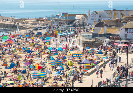 Lyme Regis, dans le Dorset, UK. 21 avril 2019. Météo France : visiteurs affluent à la plage bondée à Lyme Regis pour se prélasser au soleil brûlant le dimanche de Pâques. Se prélasser au soleil, une chaleur étouffante sur les plages de la ville sur une plaque à pâtisserie bank holiday weekend comme la côte jurassique rôtis au début du printemps une vague énorme début de stimuler l'économie locale. Credit : Celia McMahon/Alamy Live News. Banque D'Images