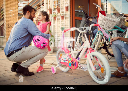 Heureux père achète smiling fille nouveau magasin de vélos en location Banque D'Images