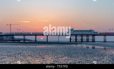 Worthing, Sussex, UK ; 20 avril 2019 ; l'aube avec lever de soleil derrière la jetée de Worthing à marée basse Banque D'Images