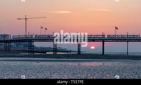 Worthing, Sussex, UK ; 20 avril 2019 ; l'aube avec lever de soleil derrière la jetée de Worthing à marée basse Banque D'Images