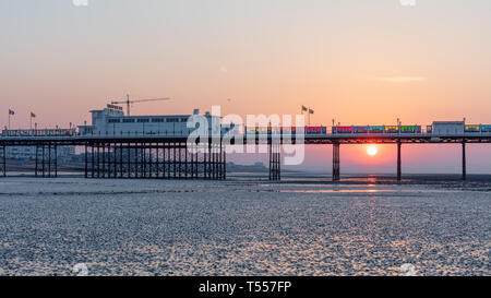 Worthing, Sussex, UK ; 20 avril 2019 ; l'aube avec lever de soleil derrière la jetée de Worthing à marée basse Banque D'Images